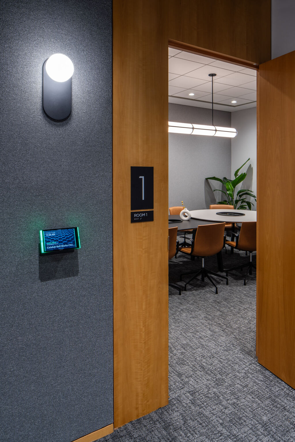 Room-control panel beside an open conference-room door
