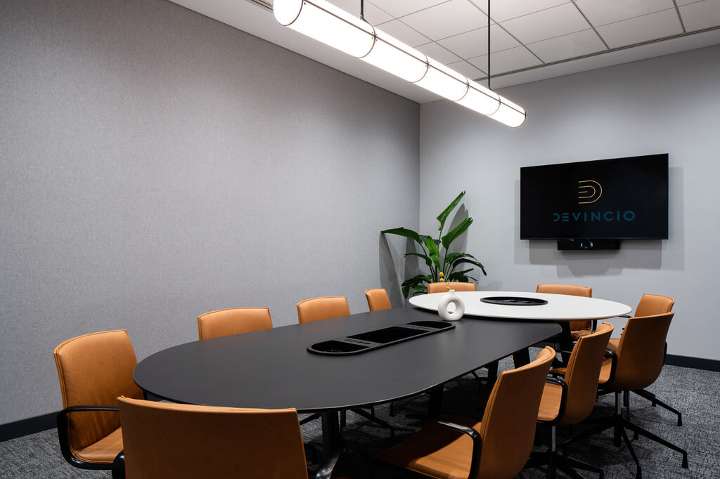 Round collaboration room with a circular table, display, and ceiling light