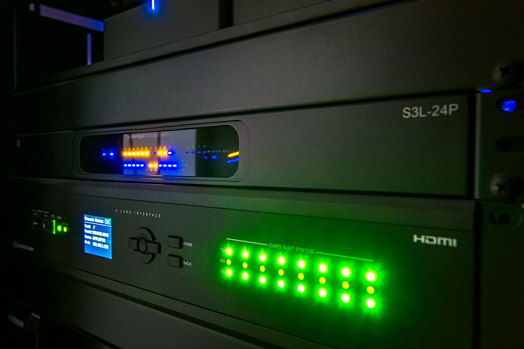 Close view of rack-mounted equipment with blue, green, and amber status lights