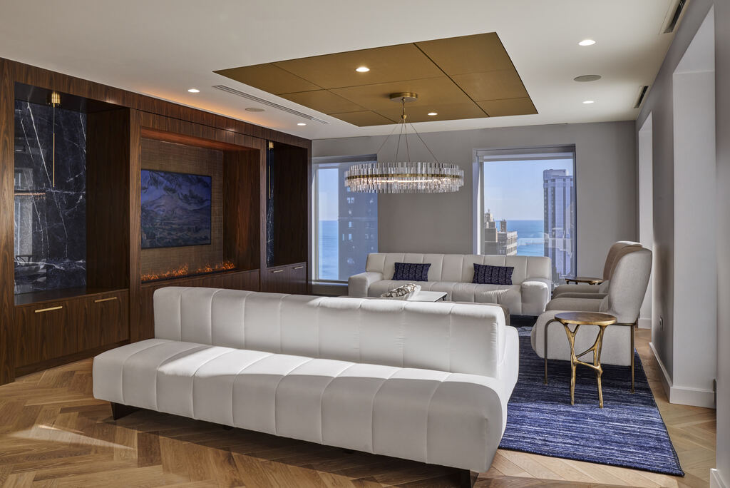 Clubroom with a white sofa, display, and wood-paneled media wall
