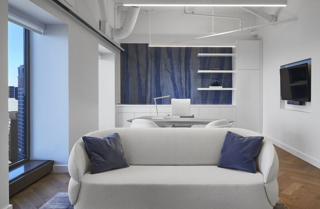 Executive space with a sofa, display, and blue accent wall